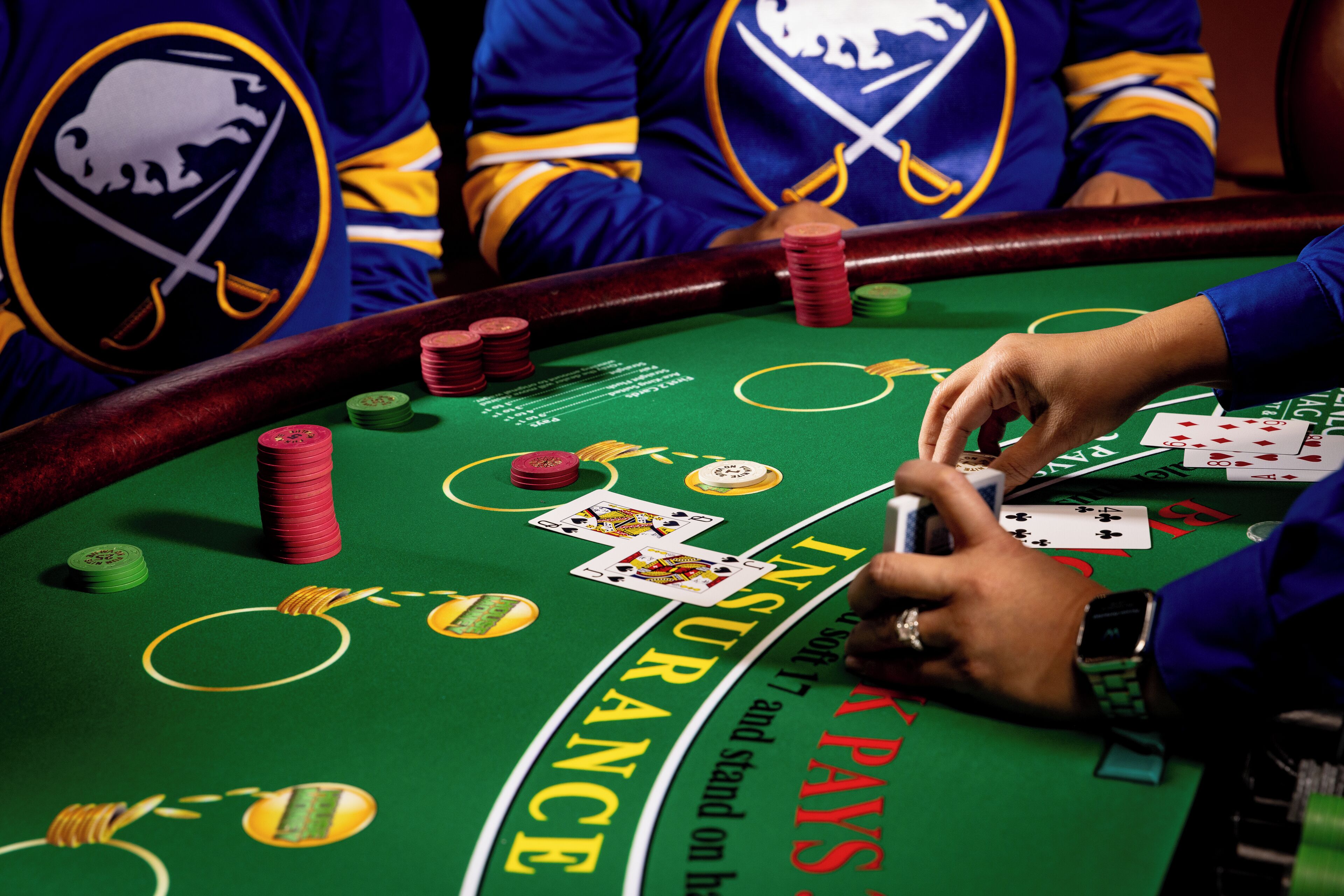 A casino blackjack table with chips and cards.