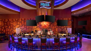 A bar area with a circular bar, multiple seating options, and a prominent sign reading "The River Bar". - Seneca Allegany Resort & Casino (Salamanca)