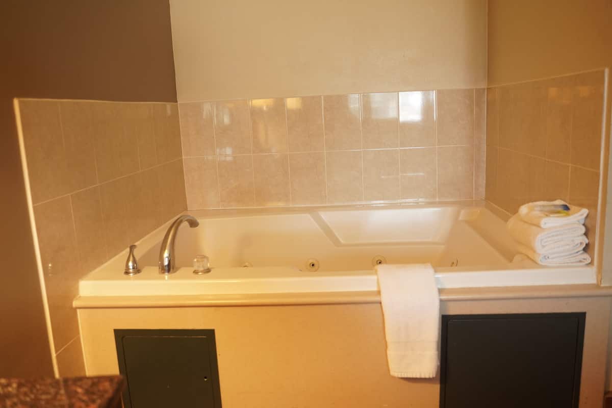 A bathroom with a bathtub, a sink, and a towel rack.