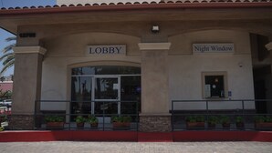 A building entrance with a 'Lobby' sign and a 'Night Window' sign. - Harbor Inn & Suites (Garden Grove)