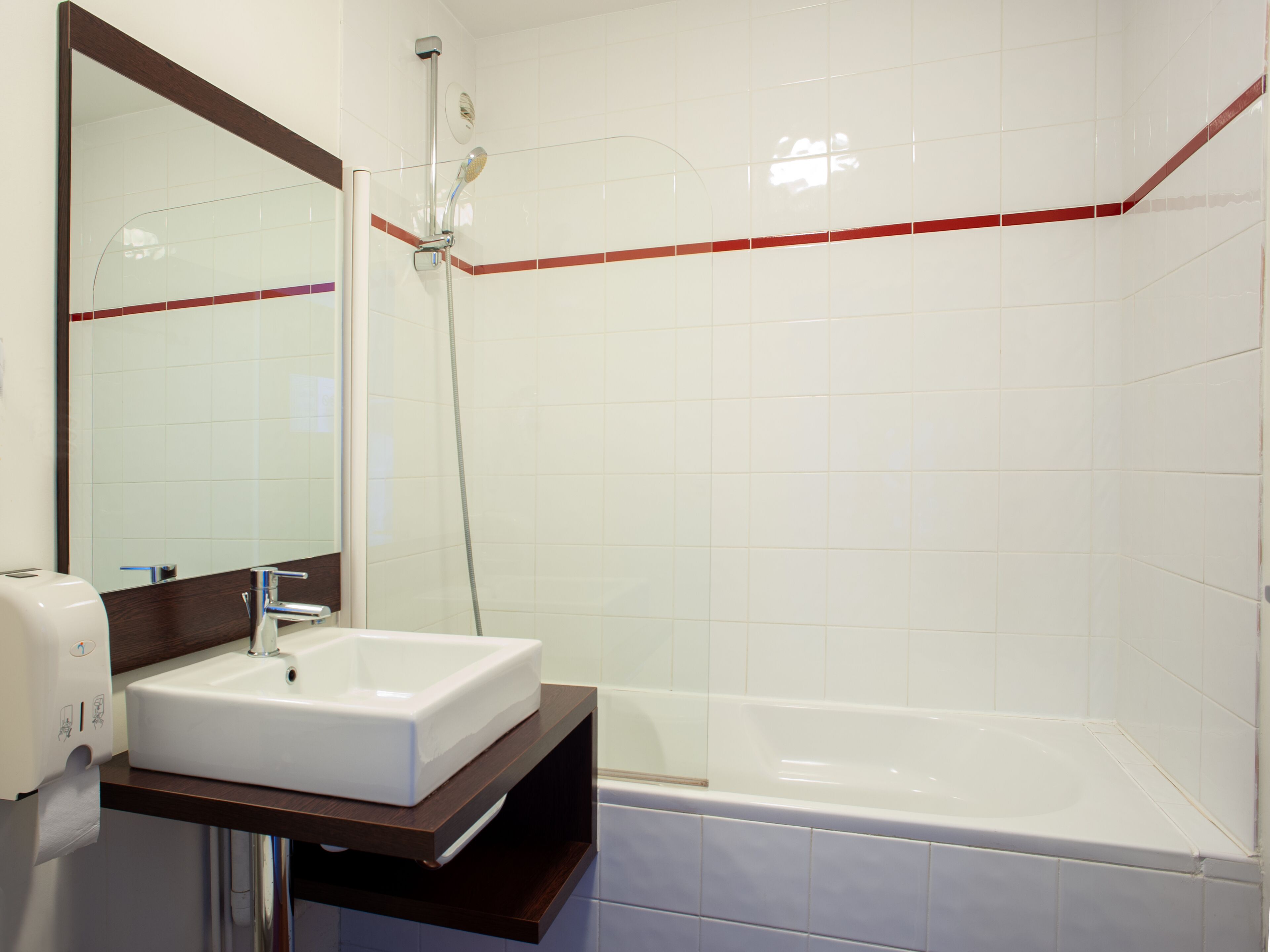 A bathroom with a white sink, a mirror, a shower, and a bathtub.