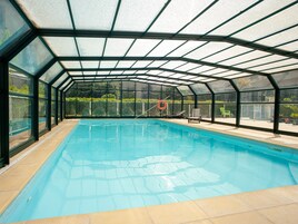 Una piscina cubierta, una piscina al aire libre de temporada, tumbonas