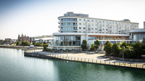 A modern hotel with a curved facade, large windows, and a waterfront view. - Waterfront Southport Hotel (Southport)
