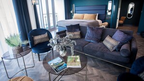 A modern hotel room with a large bed, a sofa, a coffee table, and a small side table. - Waterfront Southport Hotel (Southport)