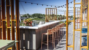 A rooftop bar with wooden railings, bar stools, and string lights. - Waterfront Southport Hotel (Southport)