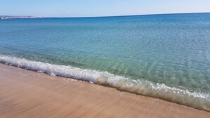 Una playa con agua cristalina y una orilla arenosa.