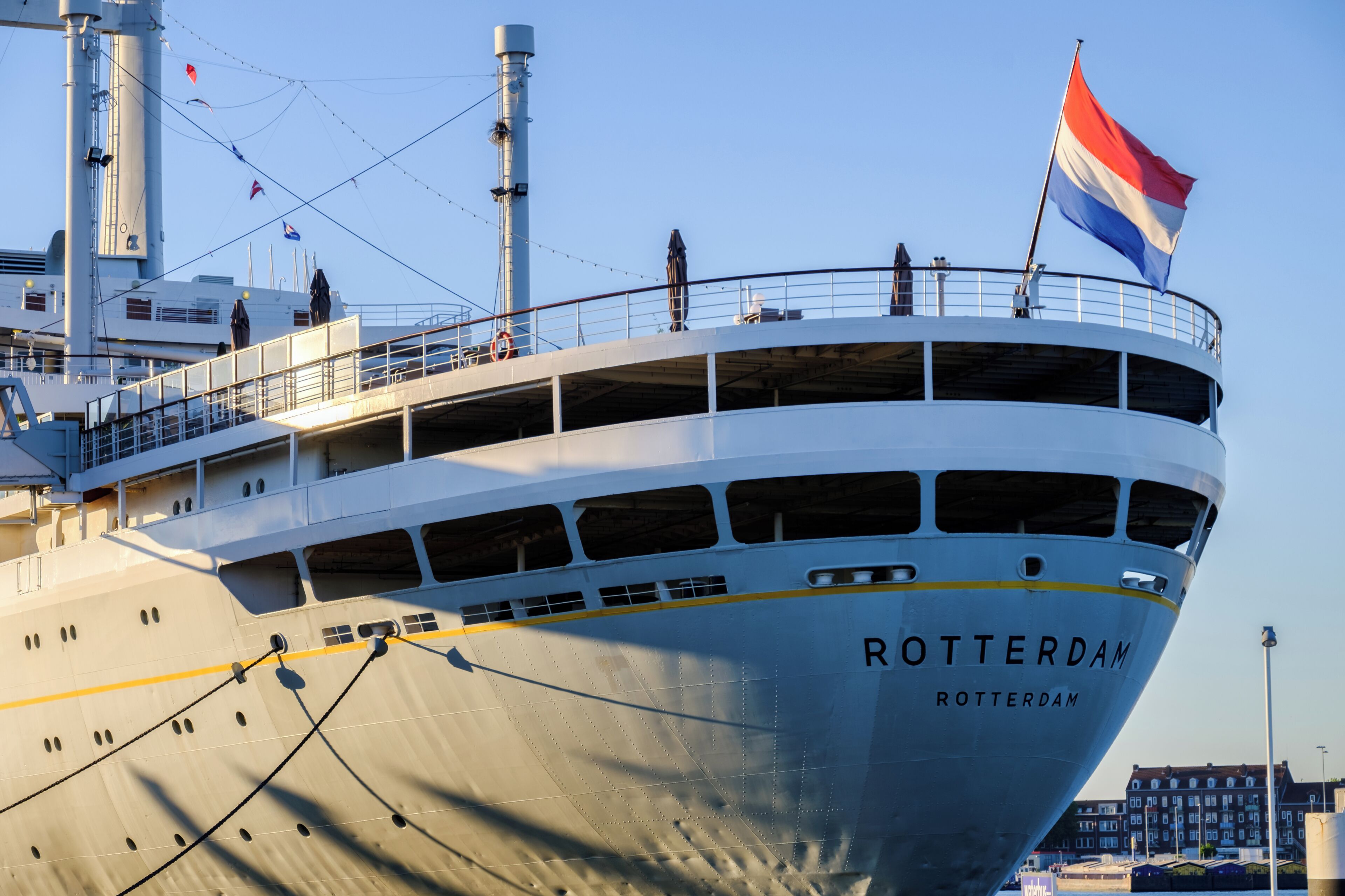 A large ship named 'Rotterdam' with multiple decks and a flag.