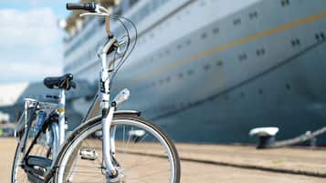 A bicycle parked in front of a cruise ship.