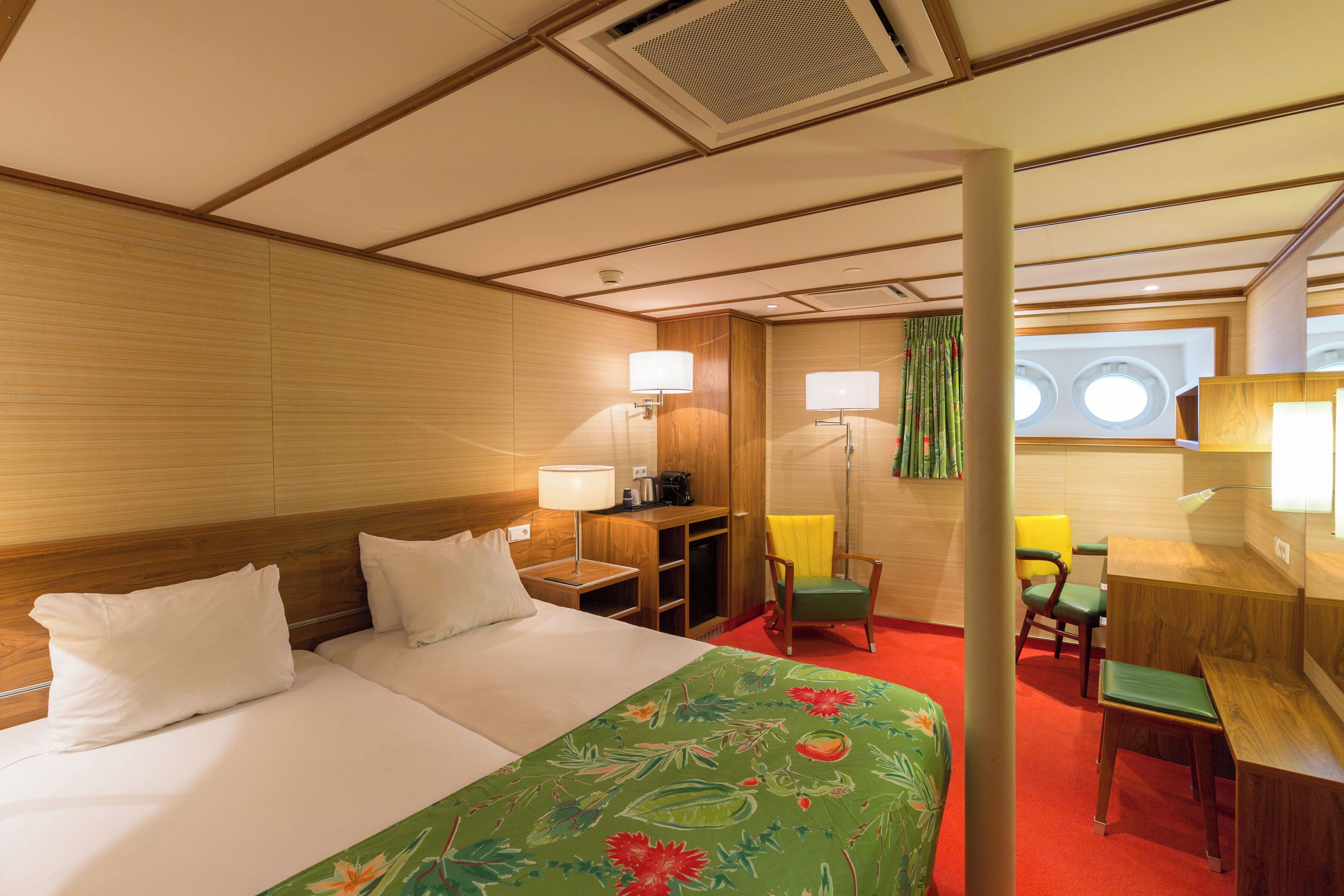 Una habitación de hotel con cama, escritorio, silla y una pequeña mesa.