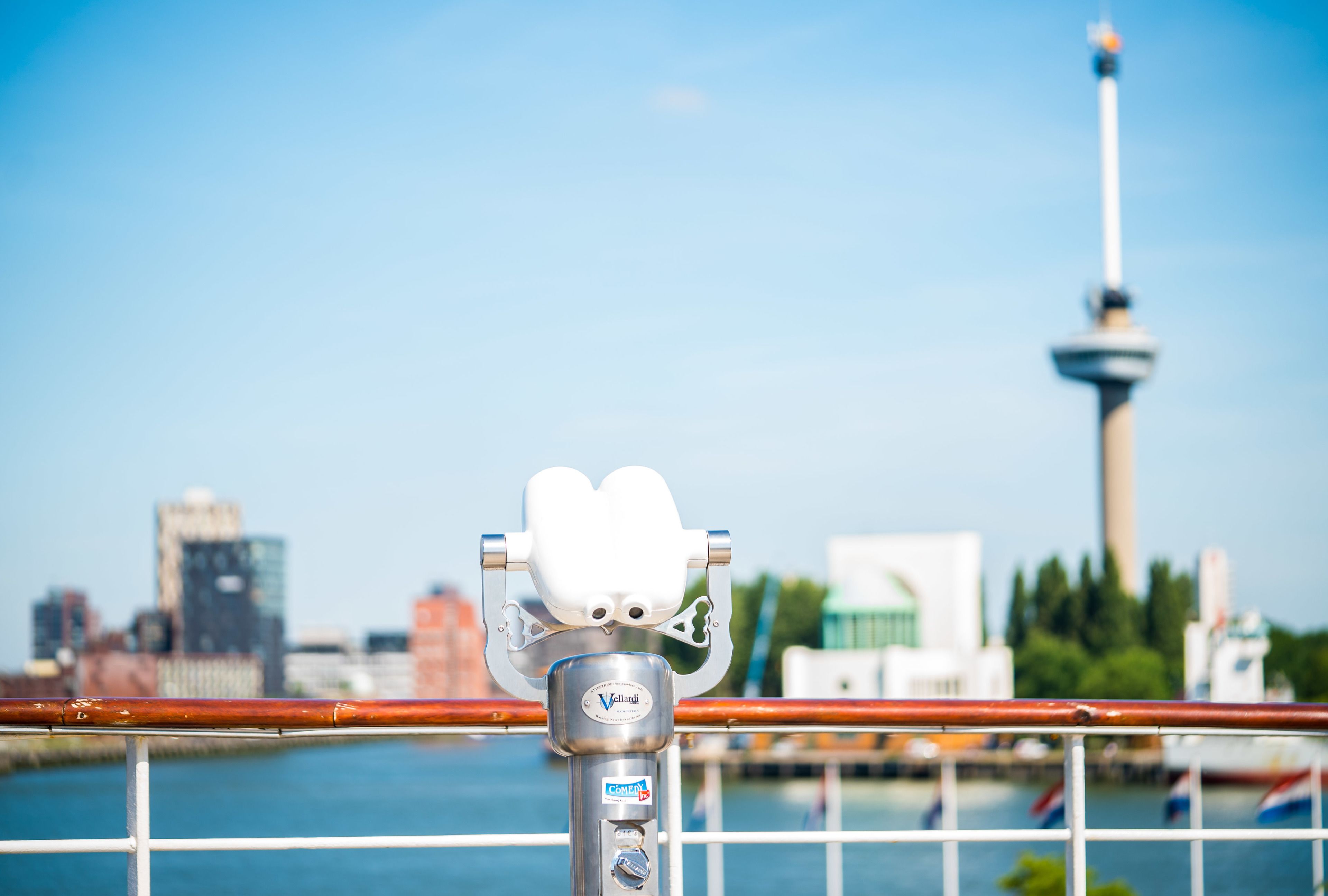 A telescope with a cityscape in the background.
