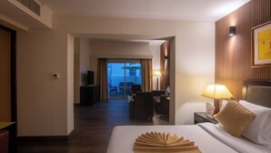 Hotelkamer met een groot bed, een bureau met lamp, een televisie en uitzicht naar buiten.