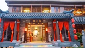 A traditional building with a tiled roof, red curtains, and lanterns. - Pazhou Hotel (Guangzhou)