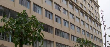 A multi-story hotel with a beige facade and numerous windows.