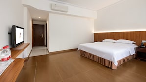 A hotel room with a bed, a TV, a bedside table, and a wooden headboard. - Pazhou Hotel (Guangzhou)