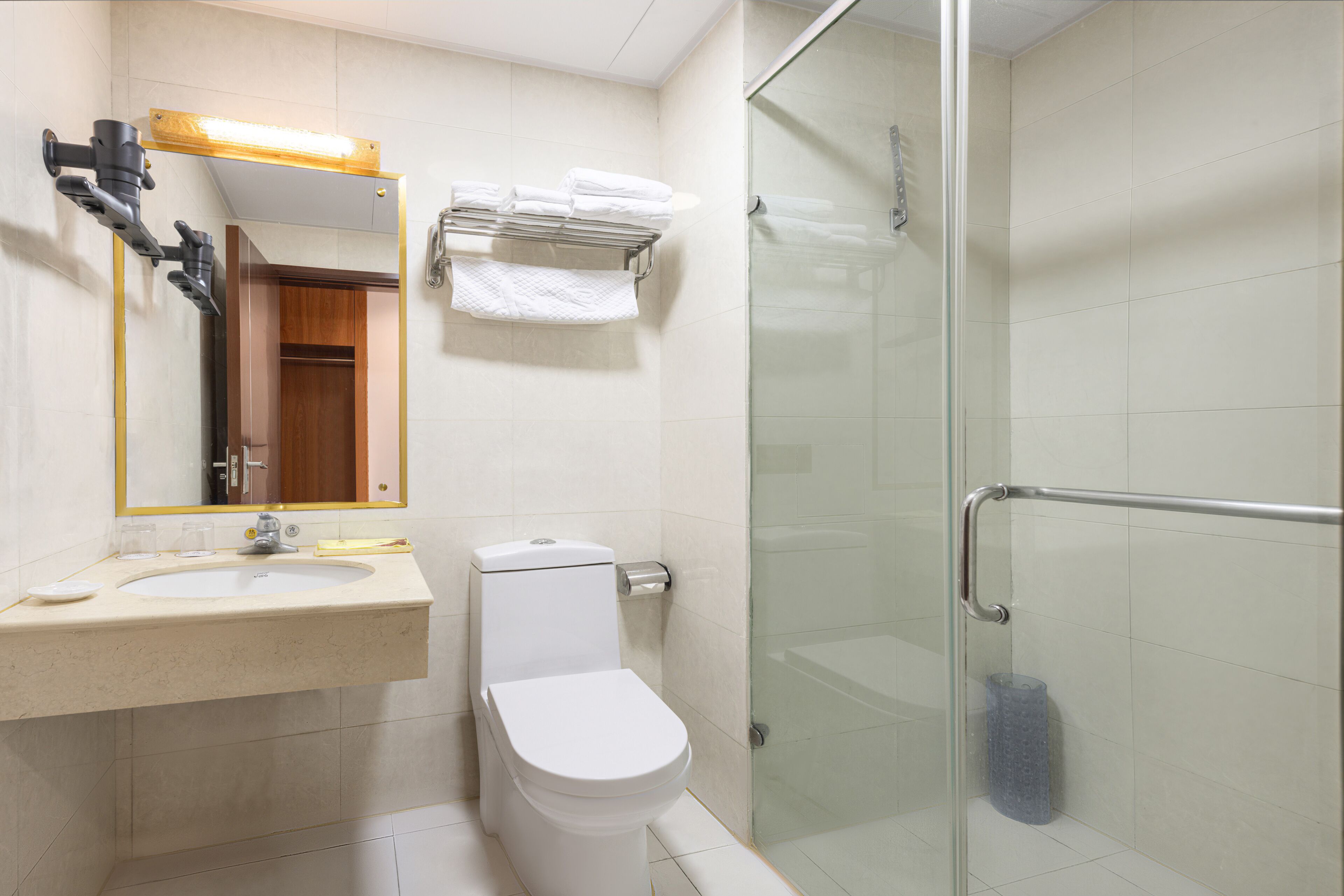 A bathroom with a sink, toilet, and glass shower enclosure.