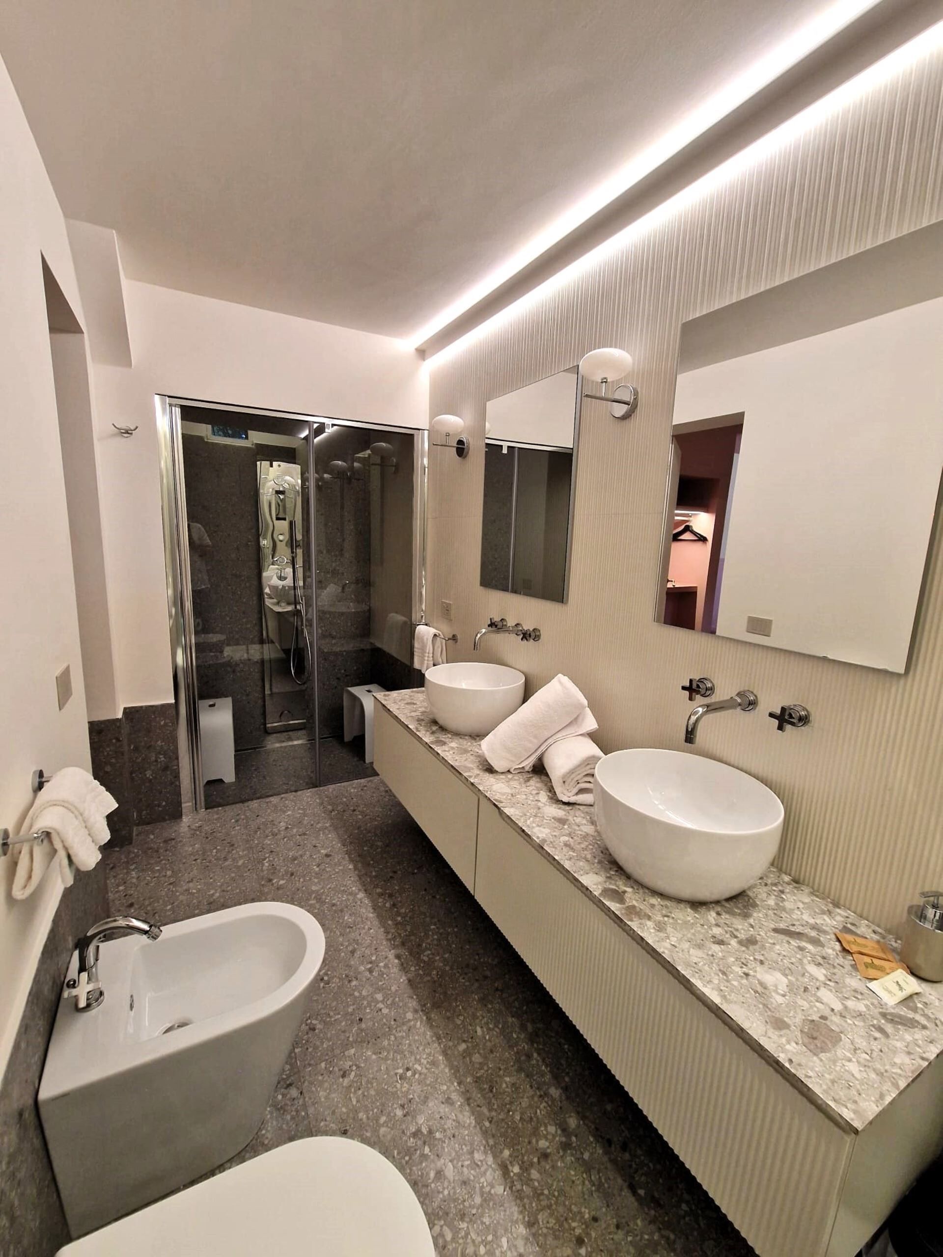 Ein modernes Badezimmer mit einer großen Badewanne, zwei Waschbecken und einer begehbaren Dusche.
