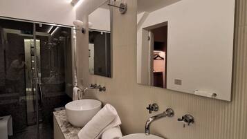 Un bagno moderno con due ampi lavabi, una doccia a filo pavimento e un grande specchio.