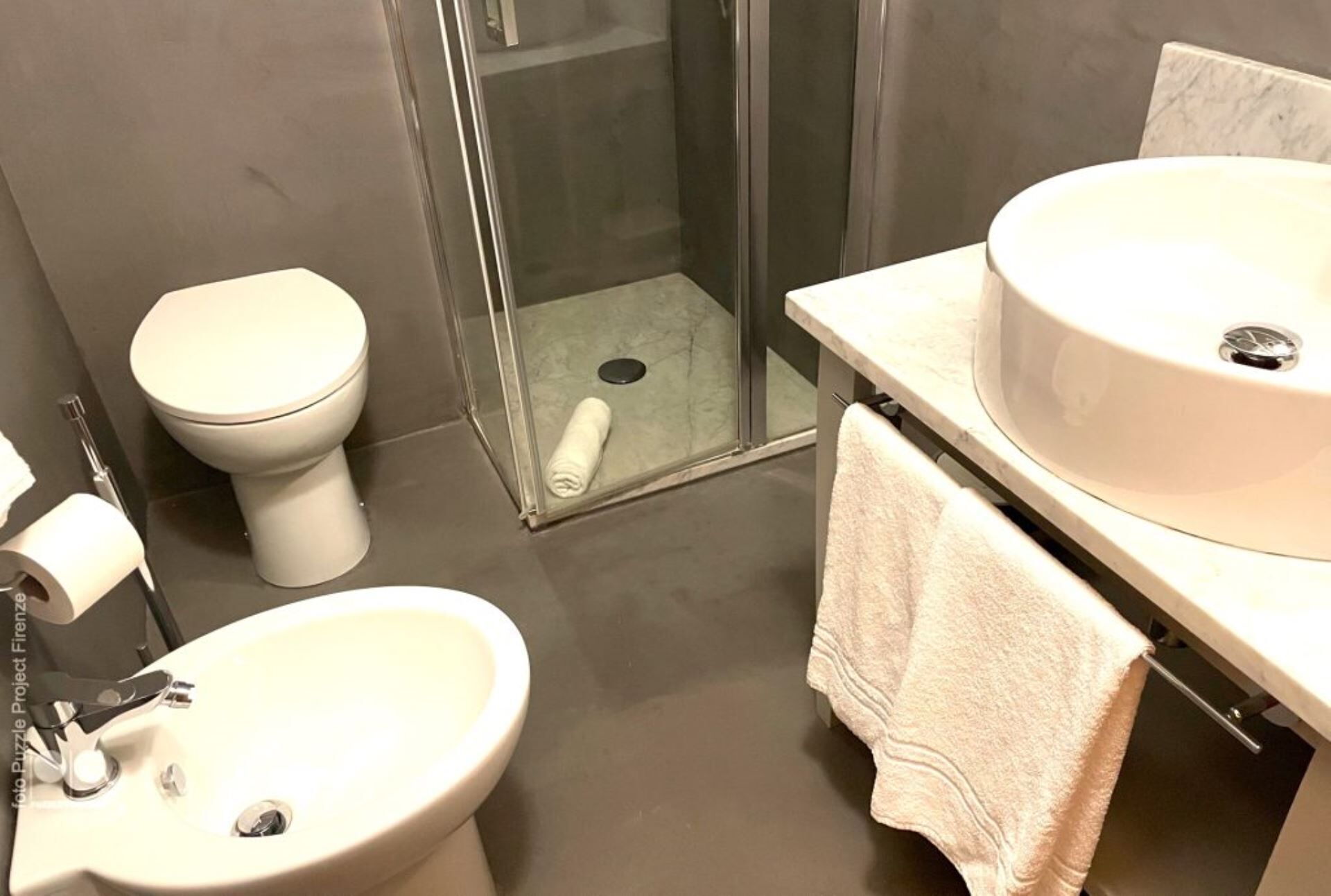 A bathroom with a toilet, bidet, and sink.