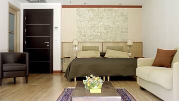 A hotel room with a bed, a sofa, a chair, a coffee table, and a decorative wall.