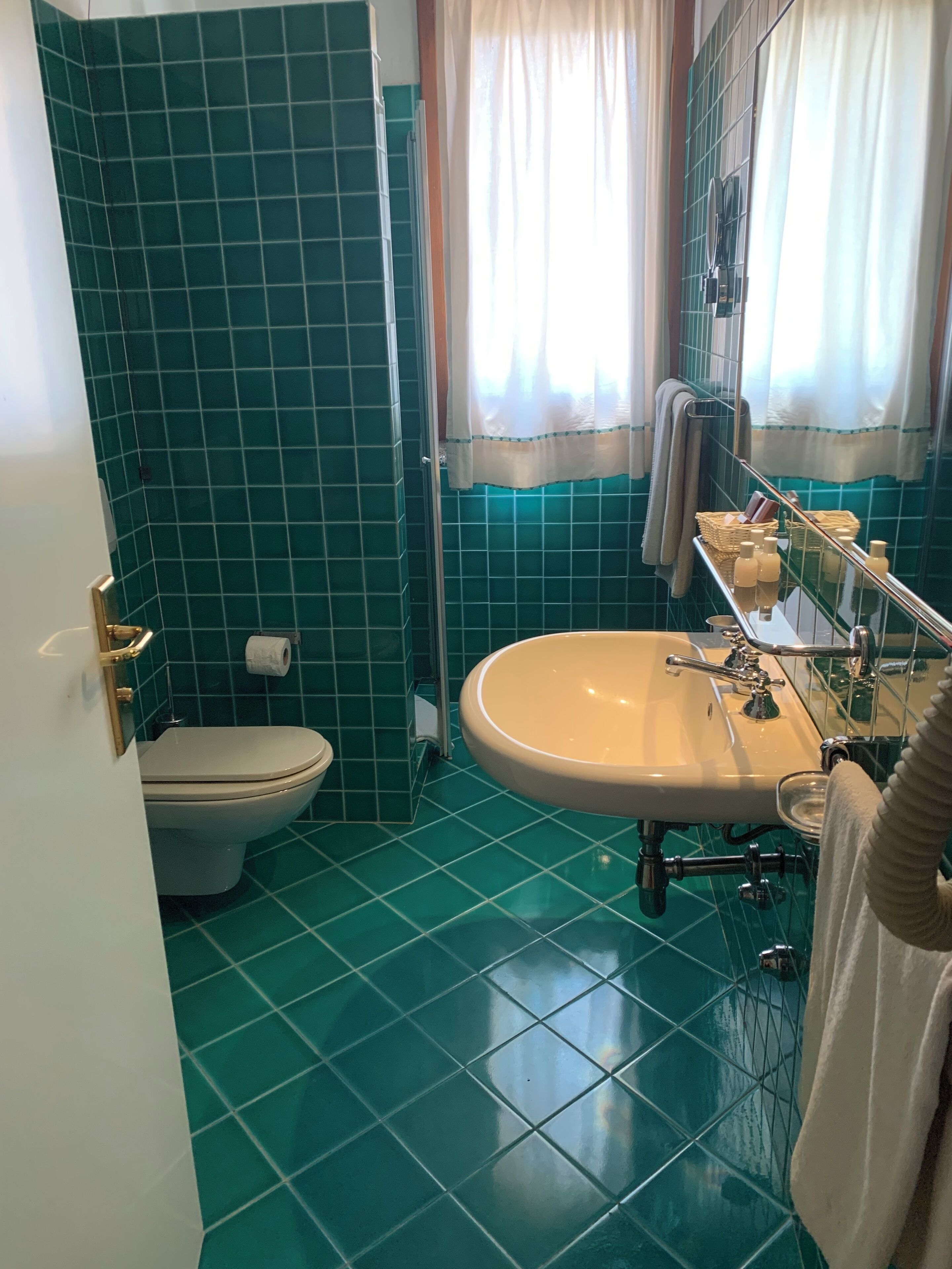 Un baño con inodoro, lavamanos y zona de ducha.