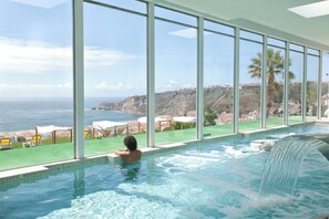 A swimming pool with a view of the sea and a waterfall feature. - Miramar Hotel & Spa (Nazaré)
