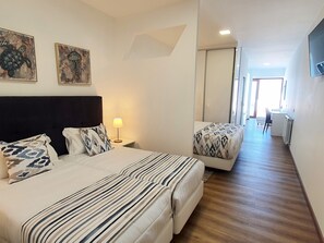 A hotel room with a large bed, two bedside tables, a lamp, and two wall-mounted paintings. - Miramar Hotel & Spa (Nazaré)
