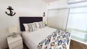 Une chambre à coucher comprenant un lit, une table de chevet, une lampe et deux supports muraux.