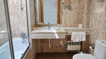 Un baño con bañera, lavamanos e inodoro.