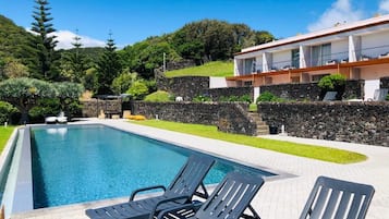 Alberca al aire libre y camastros