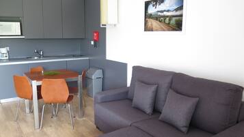 Un espacio habitable compacto con kitchenette, comedor y sofá.