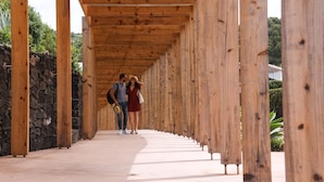 A wooden corridor with stone walls and a tiled floor. - ANC Resort (Lagoa)