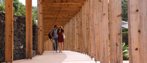 A wooden corridor with stone walls and a tiled floor.