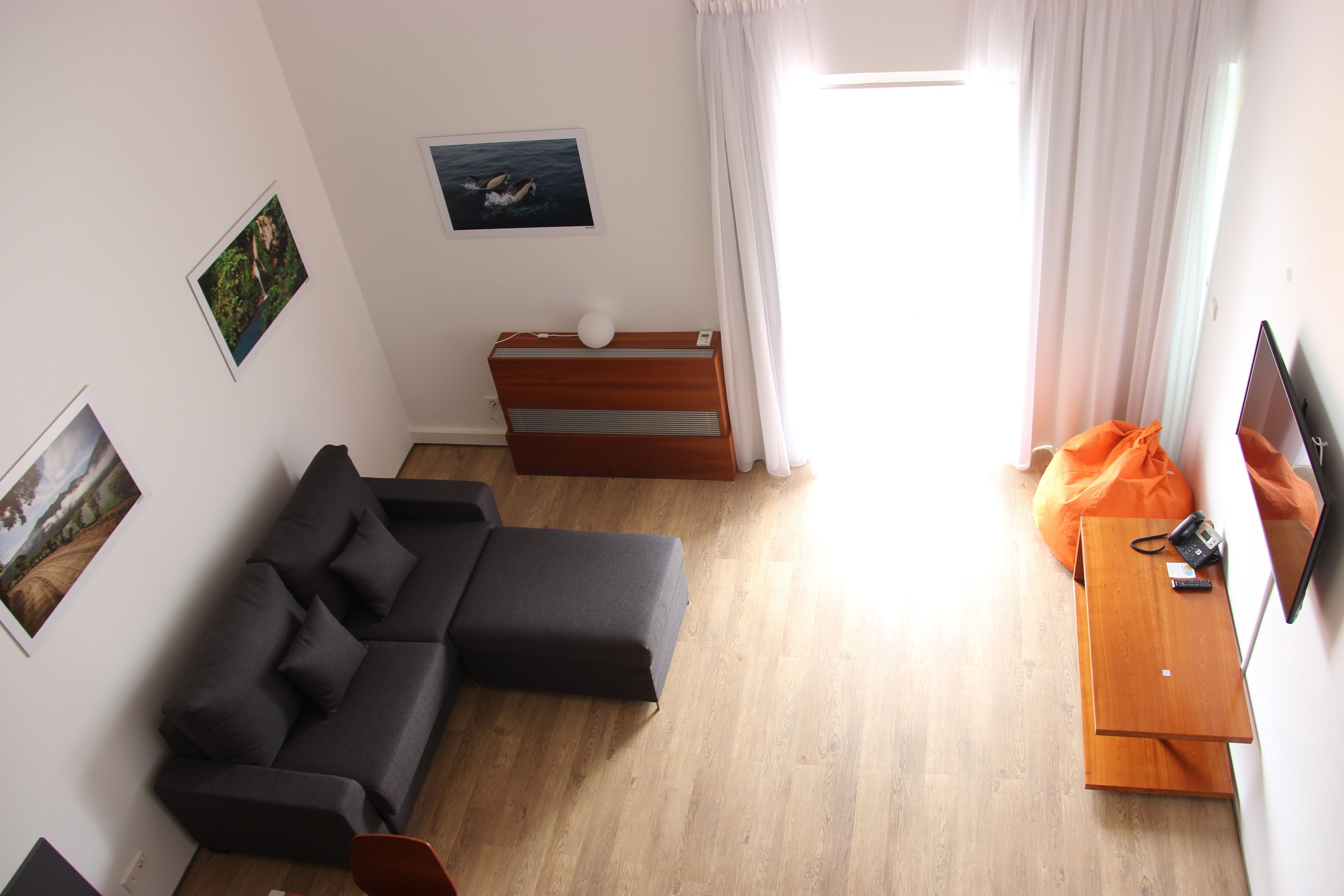 Una sala de estar moderna con un sofá modular, una mesita de madera y un televisor de pantalla plana.