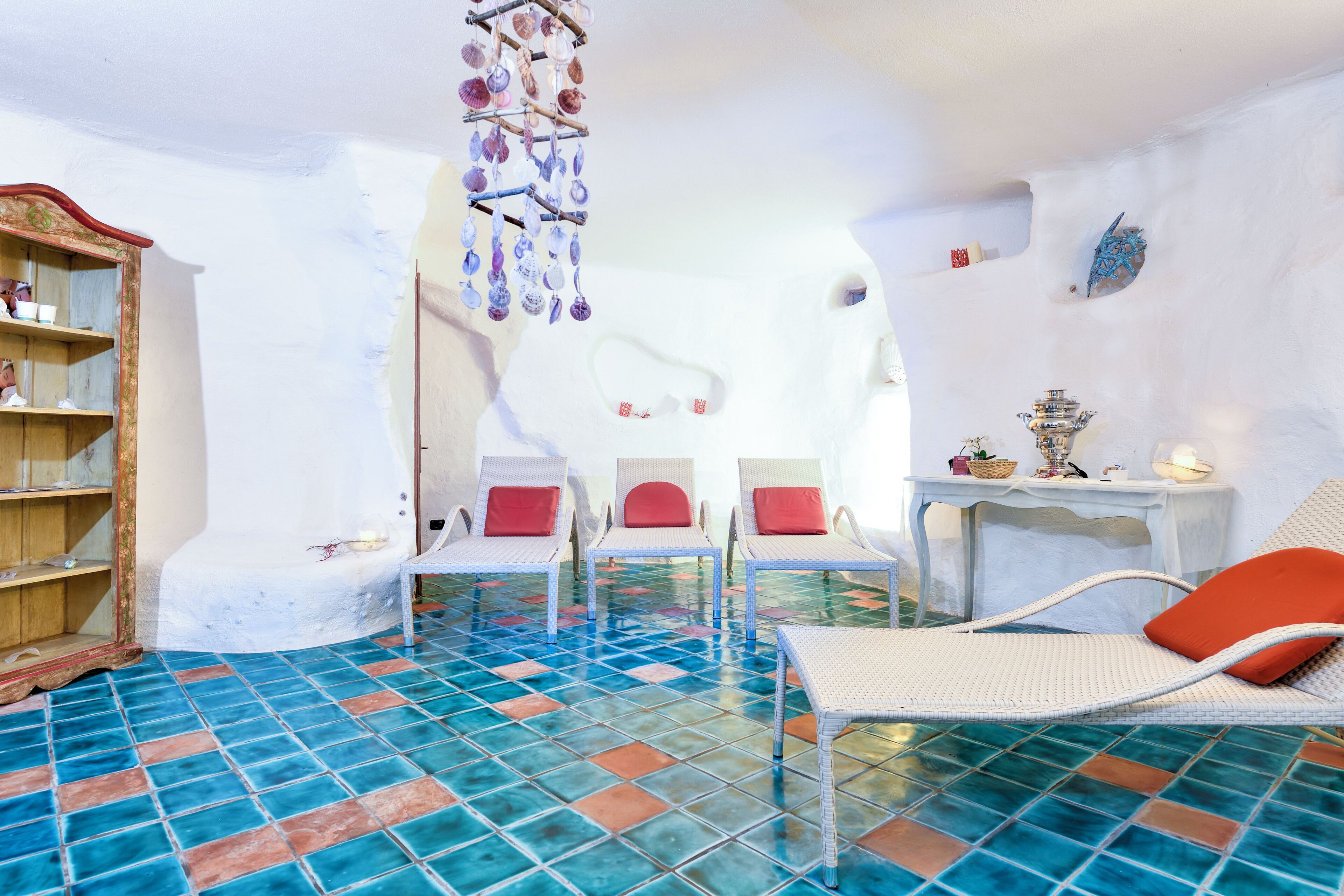 A room with a tiled floor, white furniture, and a hanging decoration.