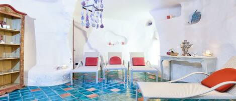 A room with a tiled floor, white furniture, and a hanging decoration.
