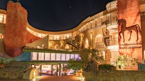 Un hôtel doté d’une grande entrée, d’une sculpture équestre imposante et d’une enseigne indiquant « Hôtel Resort & SPA BAJA CADDINAS ».