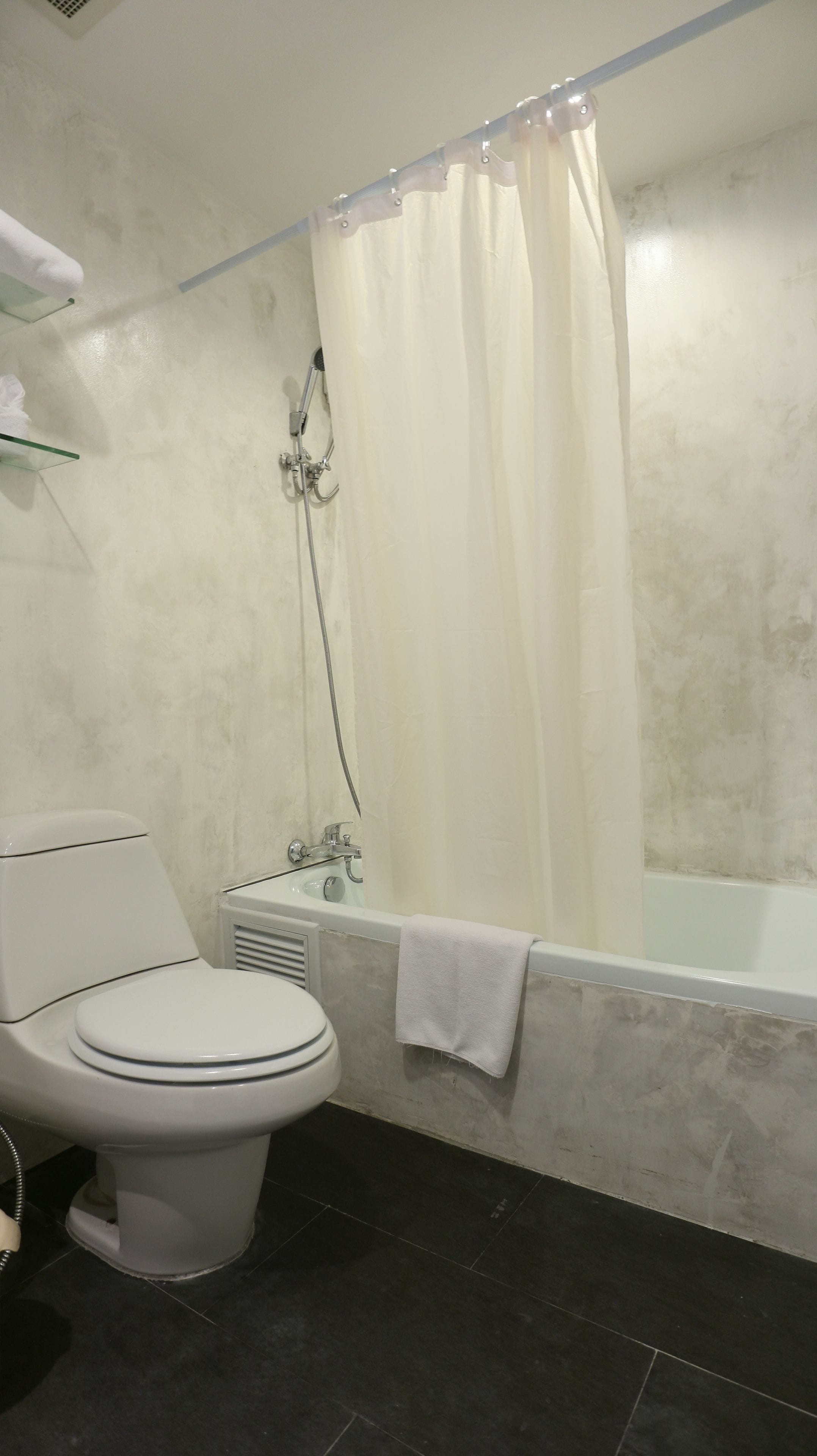 Une salle de bain avec des toilettes, une douche et une baignoire.