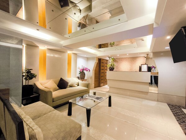 A modern hotel lobby with a reception desk, seating area, and a staircase. - The Key Sukhumvit Bangkok (Bangkok)