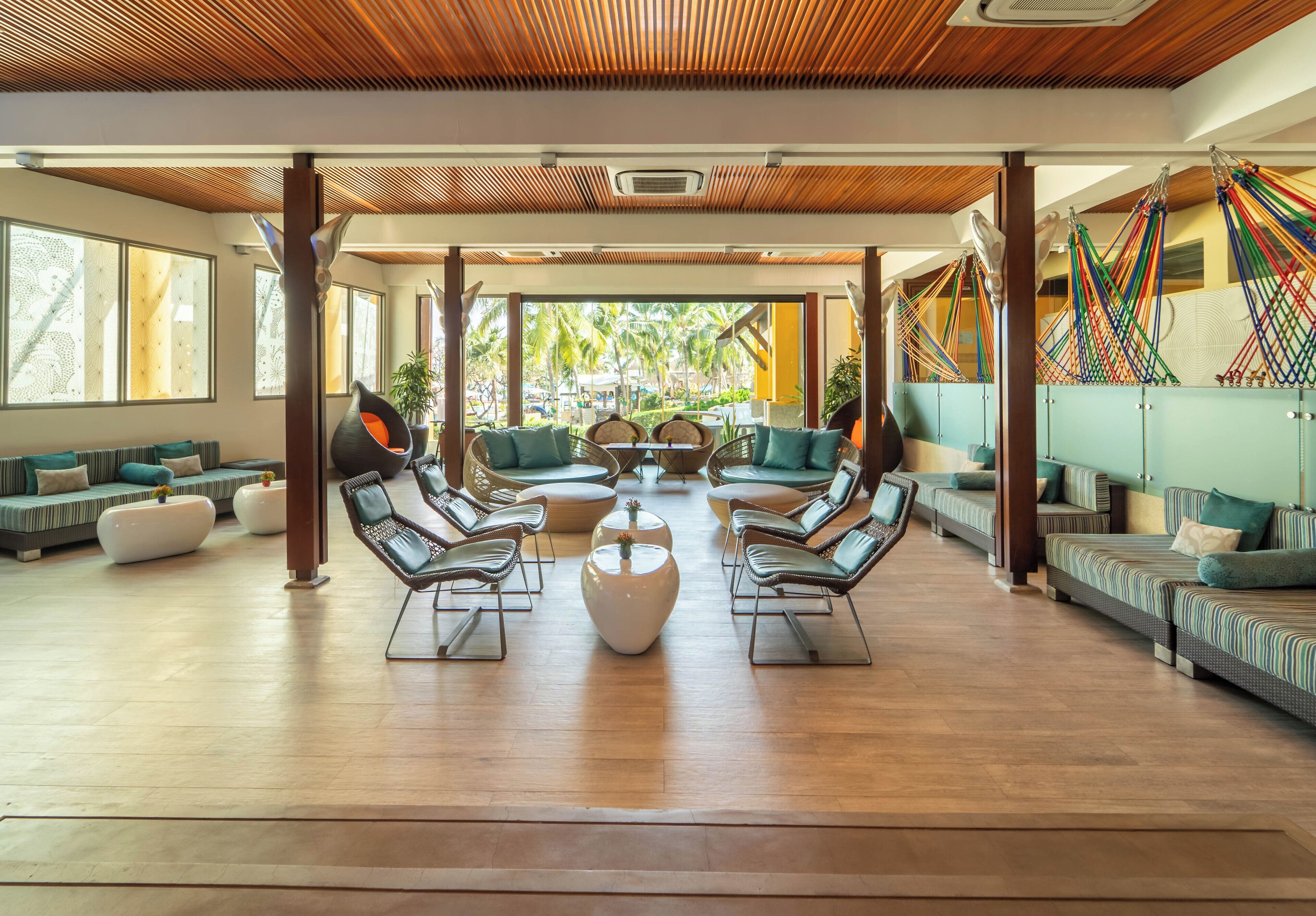 A spacious indoor area with multiple seating arrangements, including sofas and chairs, and a central coffee table.
