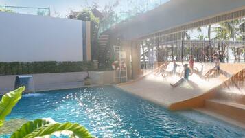 Relax by the pool surrounded by a modern architectural setting with a soothing water feature and shaded seating area.