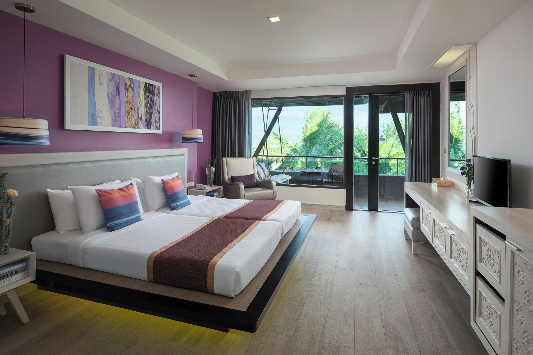 Une chambre d’hôtel moderne avec un grand lit, un balcon offrant une belle vue et un téléviseur posé sur un meuble.
