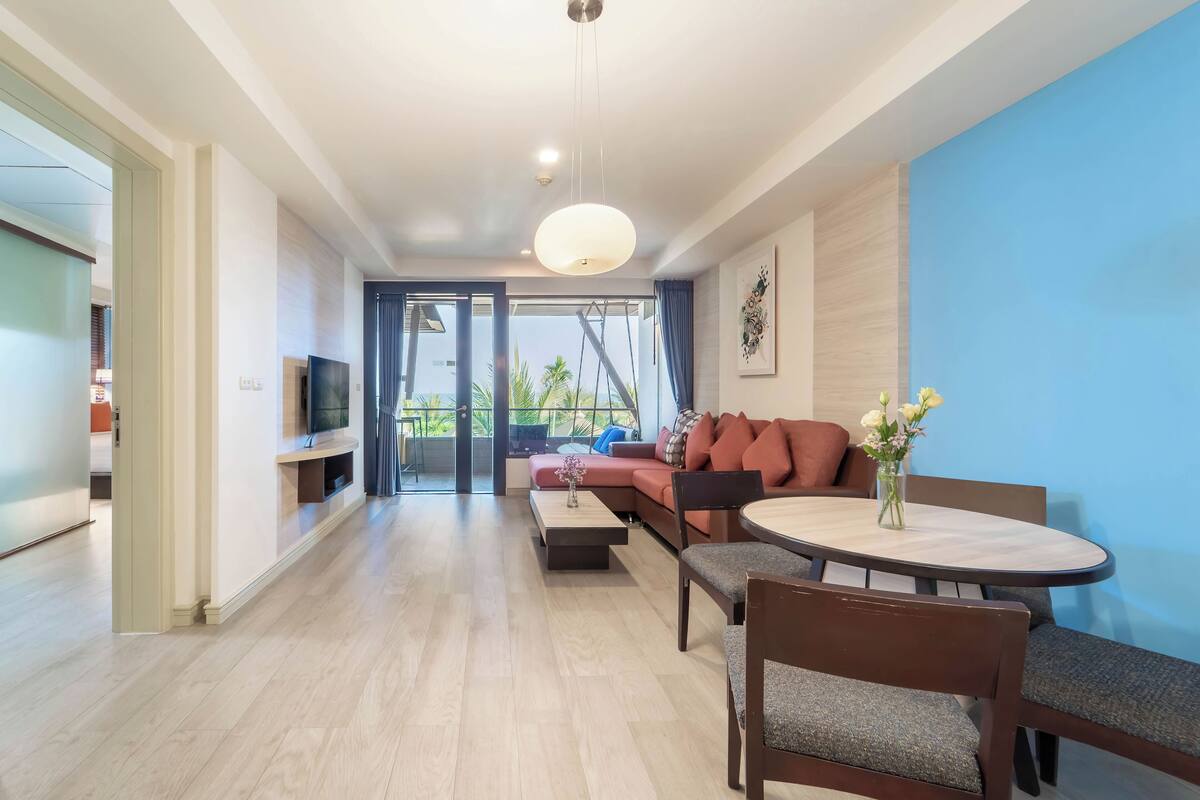 A modern living room with a sofa, coffee table, and dining table.