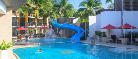 A swimming pool with a blue slide, palm trees, and lounge chairs.