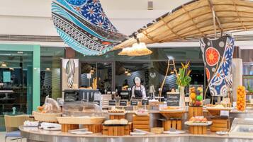 A buffet area with various food items and a chef preparing food.