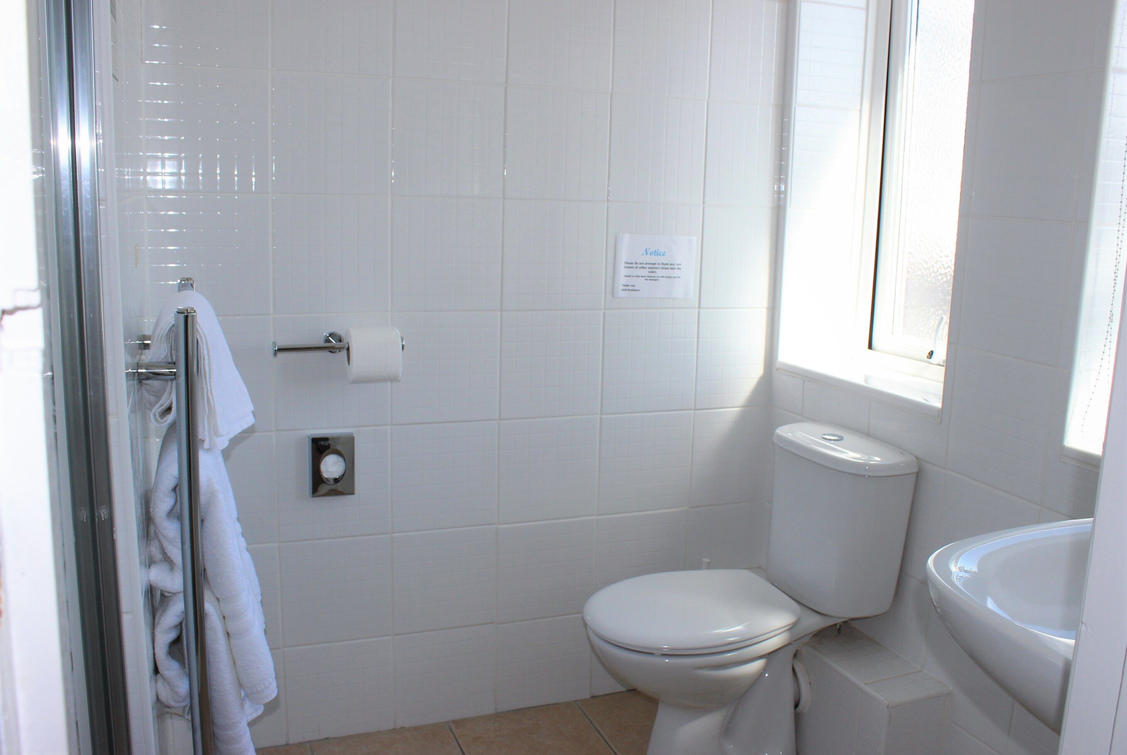 A bathroom with a toilet, a sink, and a glass shower enclosure.