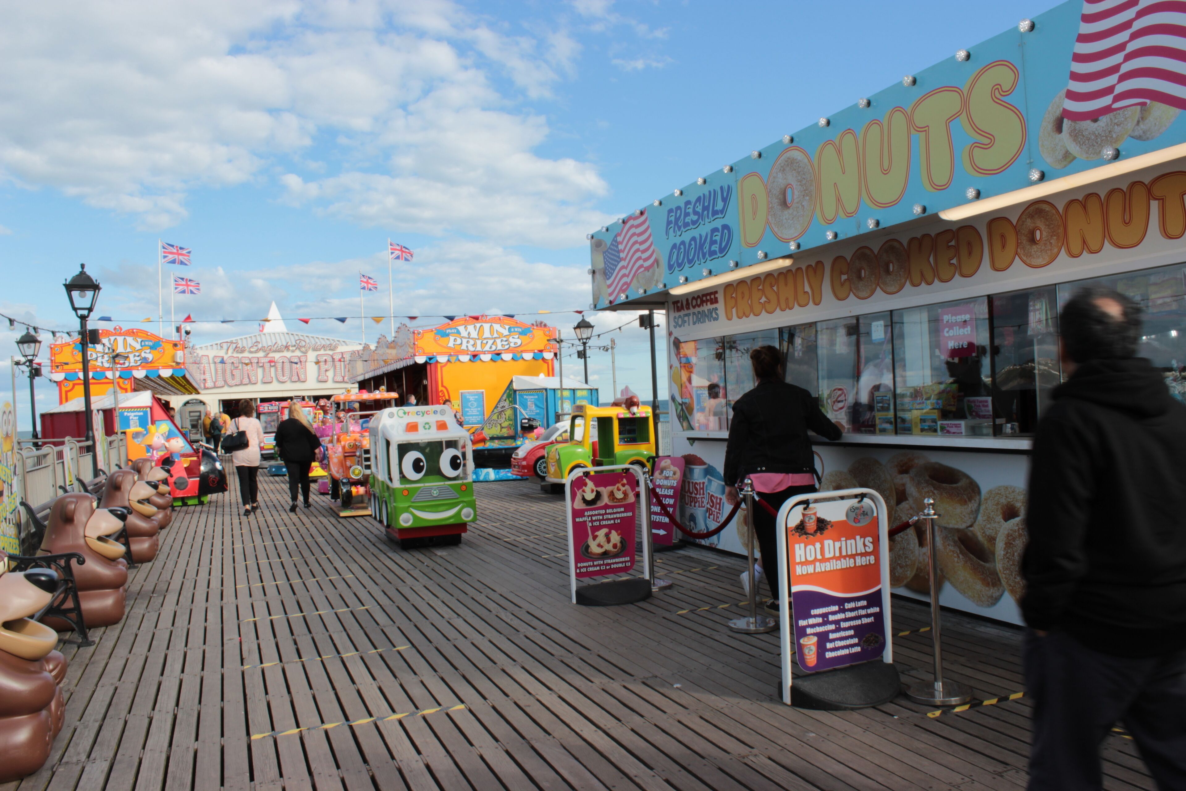 A boardwalk with a donut stand and a prize wheel game.