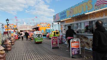 A boardwalk with a donut stand and a prize wheel game.