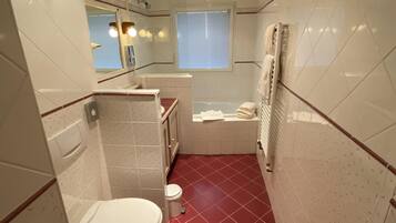 Un baño con inodoro, lavamanos y bañera.