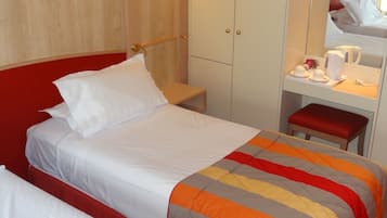 Une chambre d’hôtel avec deux lits, un bureau avec un miroir et une armoire.