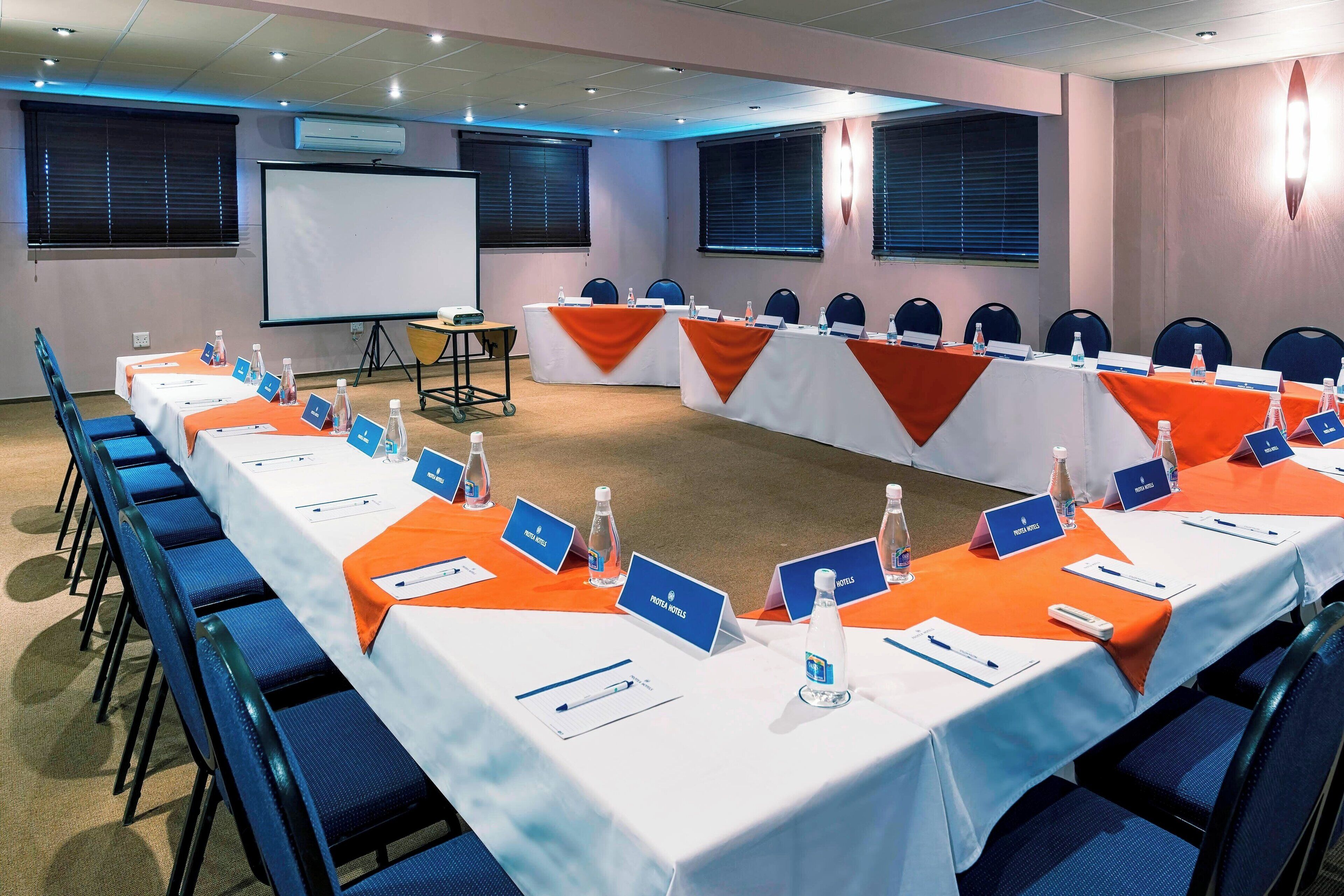 A conference room with long tables, nameplates, and water bottles.